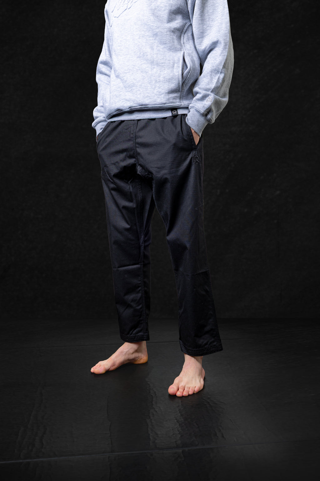 Person wearing a light blue sweater and dark pants on a black background