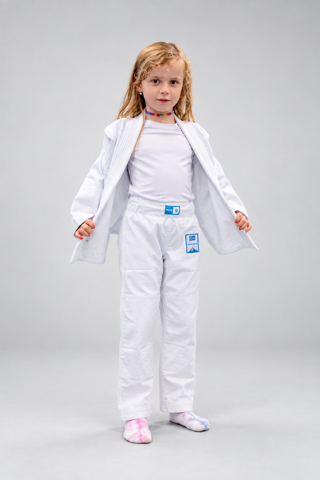 Jente i hvit Rios Kids GI med åpen jakke